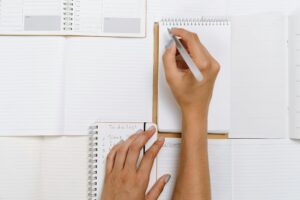 Person-Writing-on-Notebooks