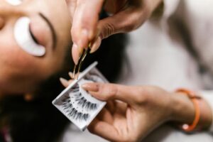 Close-Up-Shot-of-a-Person-Holding-a-Tweezer-and-False-Eyelashes